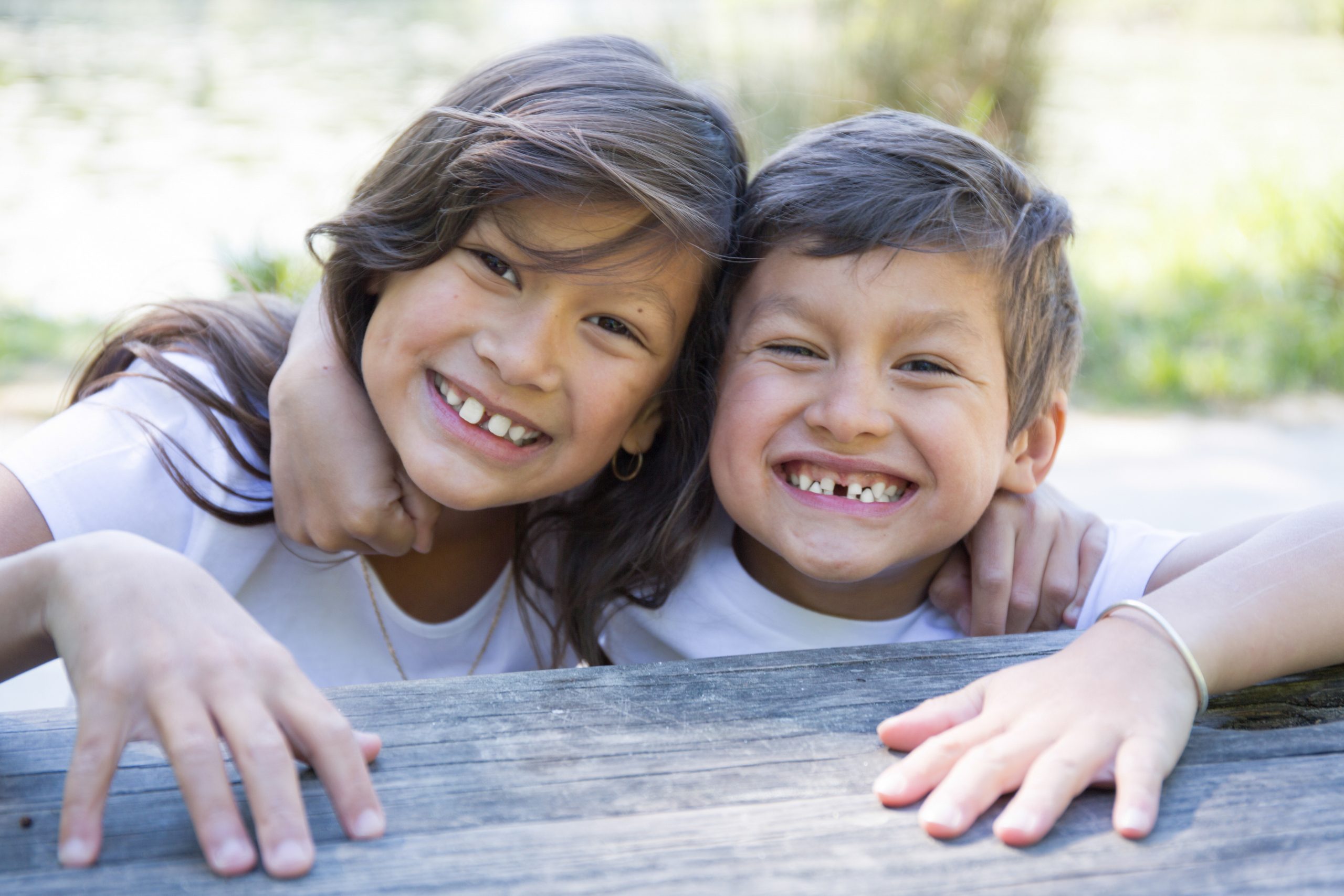 A photo of a smiling girl and boy